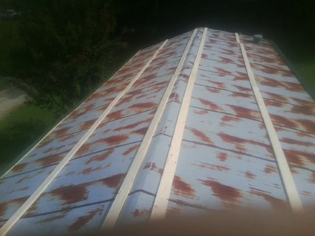 Rusted metal roof panels with new wood purlins before replacement — Storm Damage Roof Repair in Neal by Roofing Brothers
